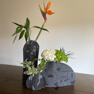 Felt vase sleeve. Handmade, eco-friendly, and sustainable decor. Upcycle recycling through a flexible designed vase cover. This is the triple vase selection of charcoal felt with the Fragment pattern for the tall and round vase sleeve and Rake pattern for the wide.